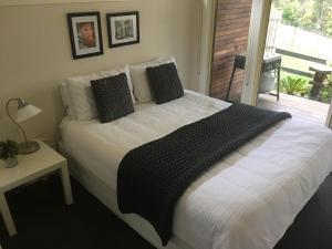 a bedroom with a white bed with a balcony at Emerald Ridge in Emerald