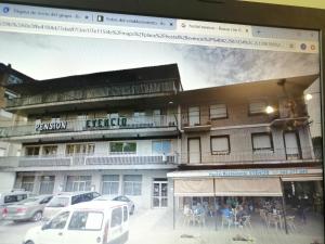 a picture of a building with people sitting outside of it at Garden Lodge Hostal Evencio in Ribadavia