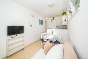 Televízia a/alebo spoločenská miestnosť v ubytovaní Apartmani Stipan