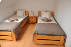 Habitación con 2 camas individuales y suelo de madera. en WISŁA-DOM PRZY RZECE, en Wisła