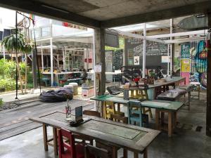 un ristorante con tavoli e sedie in una stanza di Yez Yez Yez All Good Hostel a Yogyakarta