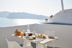 a table with two plates of food on a boat at La Perla Villas and Suites - Adults Only in Oia