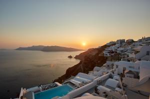 a large body of water with boats in the distance at La Perla Villas and Suites - Adults Only in Oia