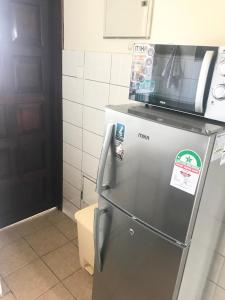 a refrigerator with a microwave on top of it at Bandari apartment in Mombasa