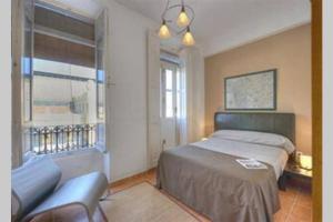 1 dormitorio con cama, sofá y ventana en Main Central Station Apartment en Valencia