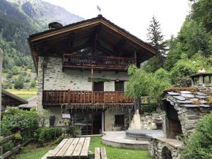 a building with a balcony on the side of it at Chalet d'en Haut Luxury and Charm in a Savoyard chalet in Les Masures