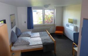 a bedroom with a bed and a window and a chair at Doppelzimmer mit Albblick in Tübingen