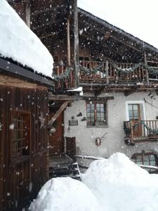 a house covered in snow with two piles of snow at Baita del Plan in Pragelato