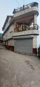 un edificio con puerta de garaje y balcón en White Tara home stay, en Darjeeling