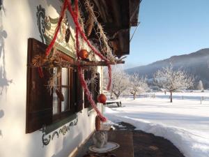 ein Haus mit Weihnachtsdekoration im Schnee in der Unterkunft Landhaus Pichler in Ruhpolding