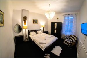 1 dormitorio con cama y lámpara de araña en Clucerului Sun Residence Villa en Bucarest