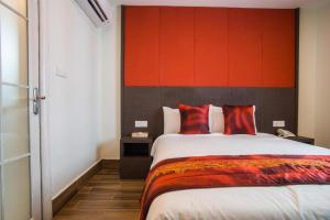 - une chambre avec un grand lit et une tête de lit rouge dans l'établissement D'Spark Hotel Bayu, à Klang