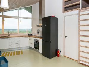 a black refrigerator in a kitchen with a window at 8 person holiday home in Ebeltoft in Ebeltoft