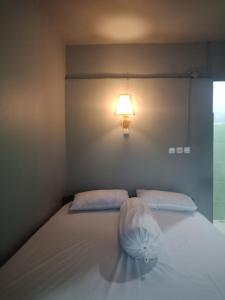 a bedroom with a bed with a light on the wall at Tunas Rinjani Inn in Masbagik