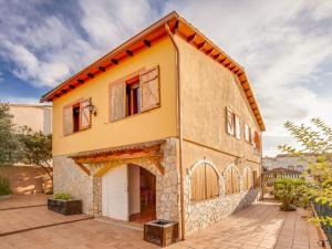 una pequeña casa amarilla con garaje en Belvilla by OYO Casa Las Palmeras, en El Vendrell