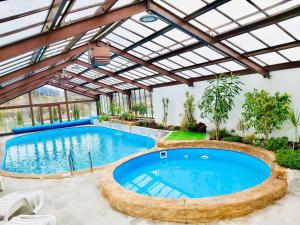 ein Hallenbad mit Pergola und Poolspiegel in der Unterkunft Park Hotel Eagle Stone in Kopriwschtiza