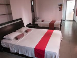 a bedroom with two beds with red and white at Backpack Lanka in Colombo