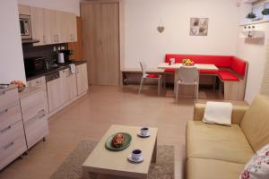 cocina y sala de estar con sofá y mesa en Apartmán Resident A001, en Harrachov
