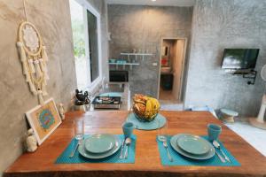 a table with plates and a basket of bananas on it at DG House in Thongsala +22 photos