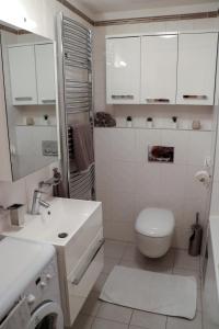 Baño blanco con aseo y lavamanos en Apartmán Resident A001, en Harrachov