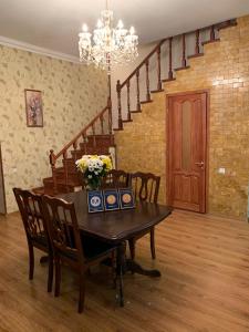 a dining room with a table and chairs and a staircase at Apartment on Zhukovskogo in Odesa