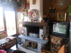 sala de estar con chimenea y TV en Terrazza con Vista Grande, en Laveno-Mombello