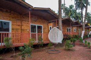 a wooden house with a chair in front of it at Mariners Bay Beach Resort in Arambol