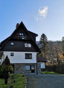 Nad Strumyczkiem - pokoje gościnne - Apartamenty z przymróżeniem oka في شتوروك: منزل أبيض كبير على سقف أسود