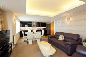 ein Wohnzimmer mit einem Sofa und einem Tisch in der Unterkunft Queens Mansions: Queens Suite in Blackpool