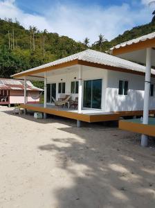 a house on the beach with a table in it at Bottle Beach 2 Bungalows in Bottle Beach