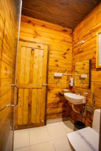 a bathroom with a sink and a wooden wall at Mariners Bay Beach Resort in Arambol