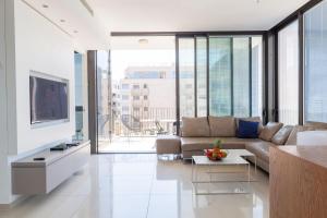 a living room with a couch and a tv at BnBIsrael apartments - Daniel Ivoire in Tel Aviv