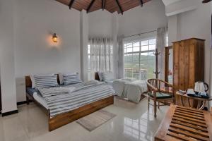 a bedroom with two beds and a large window at Misthill Rest - Lavish Villa in Nuwara Eliya