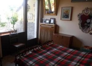 a bedroom with a bed with a plaid blanket at Terrazza con Vista Grande in Laveno-Mombello