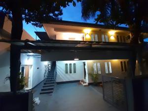 a house with a staircase in front of it at night at Beachway Inn in Alleppey
