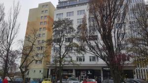 a tall building with cars parked in front of it at Apartament Gdynia KAZART.PL 3 Centrum in Gdynia