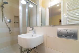 een witte badkamer met een wastafel en een spiegel bij Studio Batory in Kazimierz Dolny
