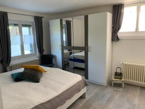 una camera da letto con un letto grande e uno specchio di La Maisonnette a Travers
