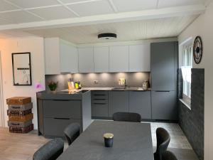 a kitchen with white cabinets and a table and chairs at La Maisonnette in Travers