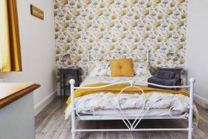 1 dormitorio con cama blanca y pared de flores en New 1 Bed First Floor Flat in Central Fareham, en Fareham