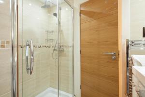 a shower with a glass door in a bathroom at Queens Mansions: Princess Suite in Blackpool