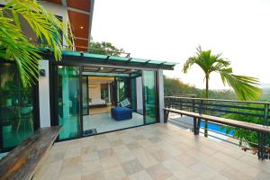a glass house with a bench on a balcony at Ao Luek Panoramic Pool-SHA Plus in Ao Luk