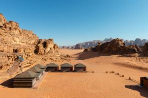 a group of tents in a desert with rocks at Sand Star Camp in Wadi Rum