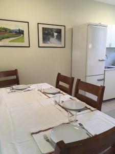 a table with a white table cloth and a refrigerator at Harangláb Apartman Tata in Tata