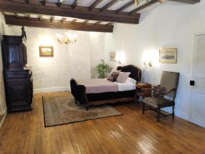 - une chambre avec un lit et une chaise dans l'établissement Chateau de Balsac, à Balsac