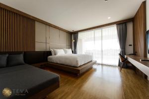 a bedroom with a bed and a couch and a window at TEVA Valley Resort in Chiang Rai