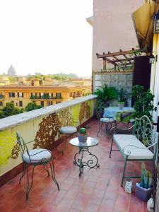 un patio con mesas y sillas en el balcón en Meraviglioso Attico con Terrazza Panoramica en Roma