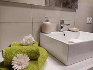 a bathroom with a sink and a green towel chair at Appartamento "Il Vicolo" in Peschiera del Garda +55 photos