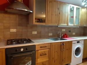 una cocina con estufa horno superior al lado de un fregadero en Casa MAEL - CIR 0017, en Saint-Pierre