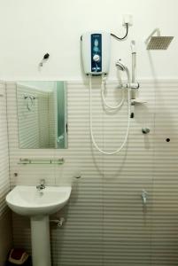 La salle de bains est pourvue d'une douche et d'un lavabo. dans l'établissement Kanora lake resort, à Maharagama